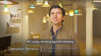 Sebastian Betanzo, co-founder of PET Lamp luxury lighting, in tan leather jacket standing in lighting showroom with recycled plastic bottle pendant lights and wicker lampshades