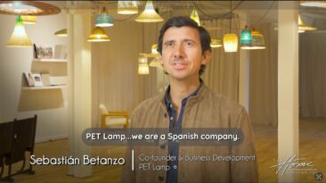 Sebastian Betanzo, co-founder of PET Lamp luxury lighting, in tan leather jacket standing in lighting showroom with recycled plastic bottle pendant lights and wicker lampshades