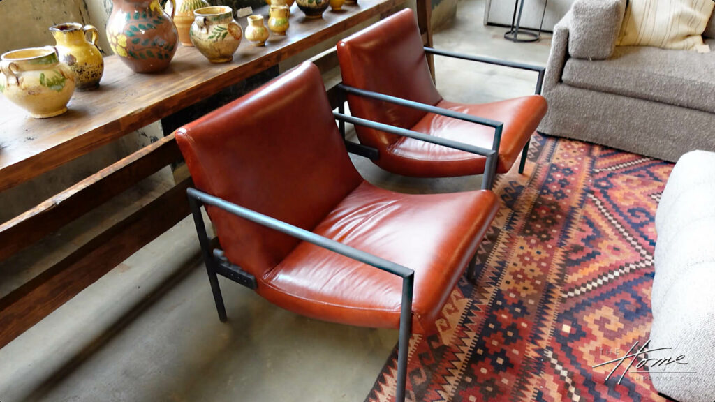 2 red leather and black metal Cisco Home Furniture side chairs on multicolored geometric pattern rug