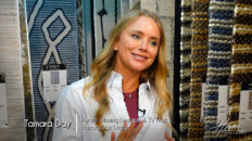 Image: blonde smiling woman Tamara Day in button down white shirt standing in rug showroom