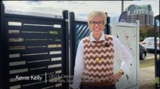 woman with blond short hair in burgundy and pink vest outside in front of laser-cut architectural railings